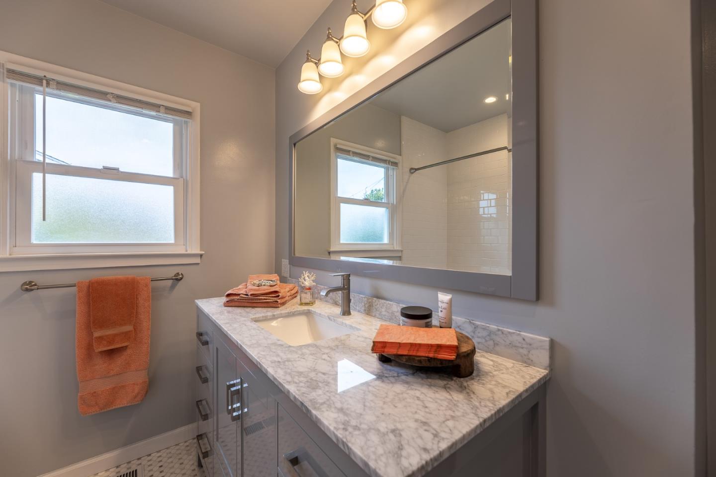 1130 Ripple Avenue Pacific Grove, CA 93950 - Photo 13 of 38 a bathroom with a granite countertop sink and a mirror