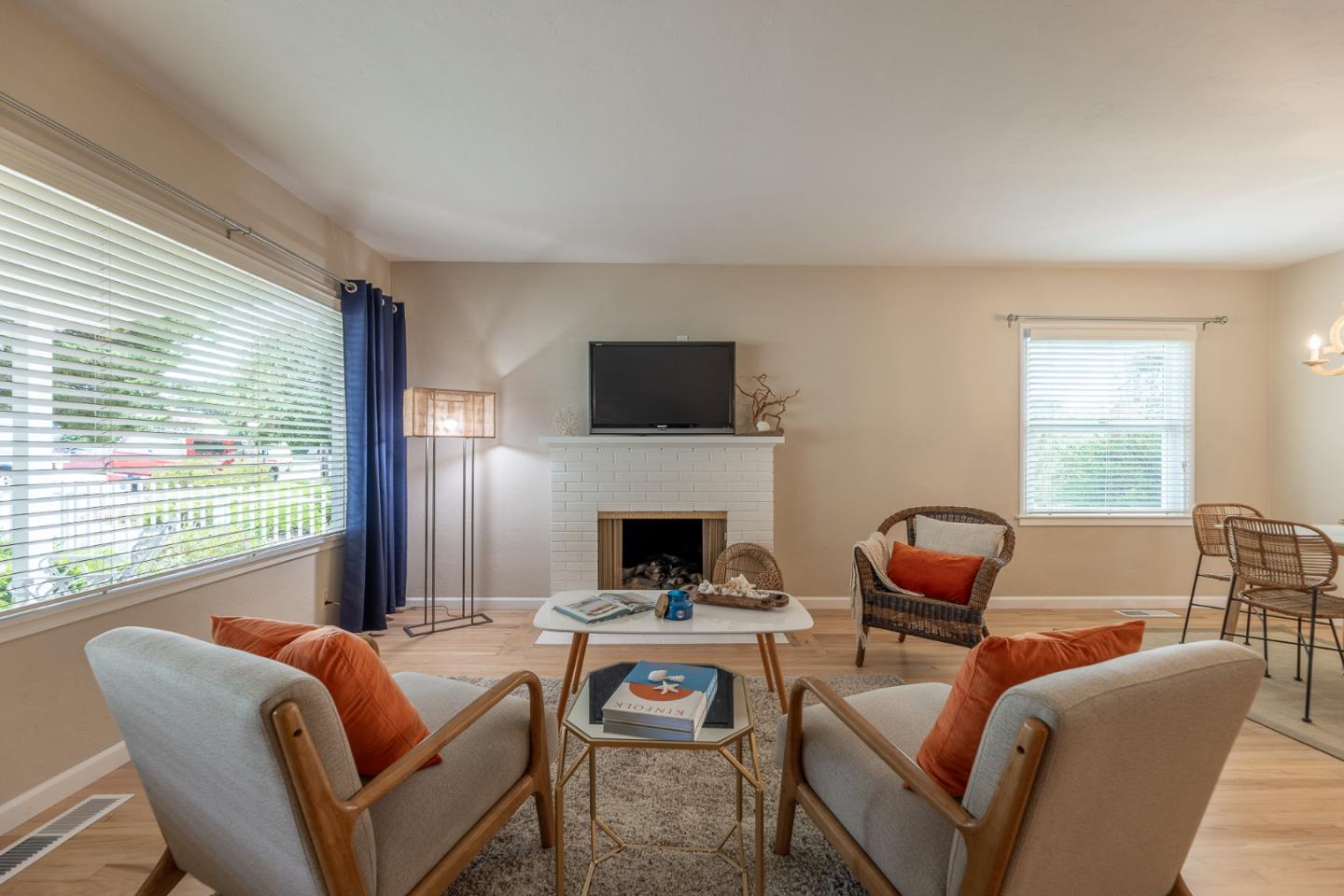 1130 Ripple Avenue Pacific Grove, CA 93950 - Photo 6 of 38 a living room with furniture a flat screen tv and a fireplace