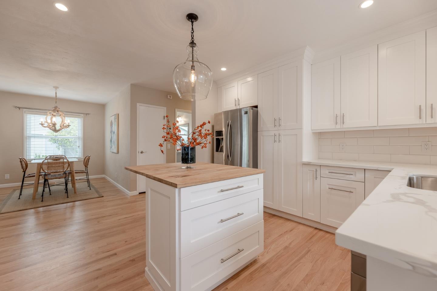 1130 Ripple Avenue Pacific Grove, CA 93950 - Photo 9 of 38 a kitchen with kitchen island white cabinets and stainless steel appliances