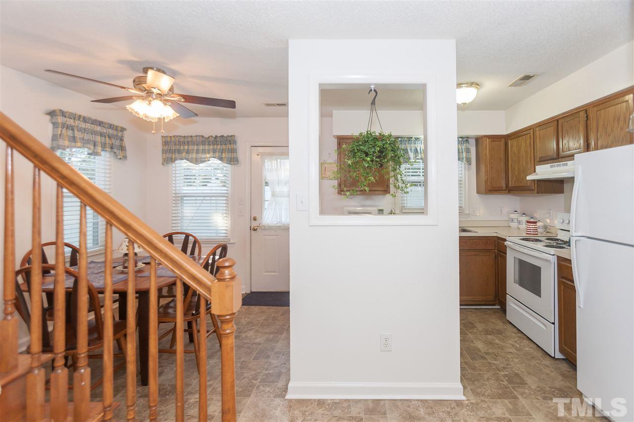 2959 Faversham Place Raleigh, NC 27604 - Photo 9 of 23 a kitchen with stainless steel appliances a refrigerator a stove a microwave oven a dining table and chairs with wooden floor