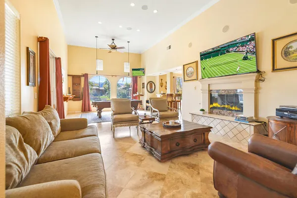 a living room with furniture kitchen view and a large window