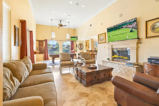 a living room with furniture kitchen view and a large window