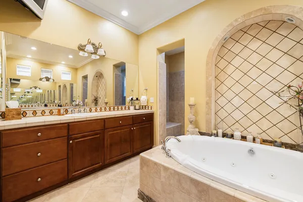 a bathroom with a double vanity sink mirror and bathtub