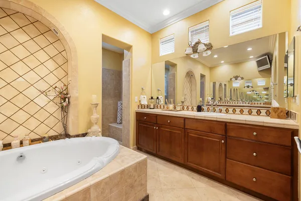 a spacious bathroom with a tub sink and mirror