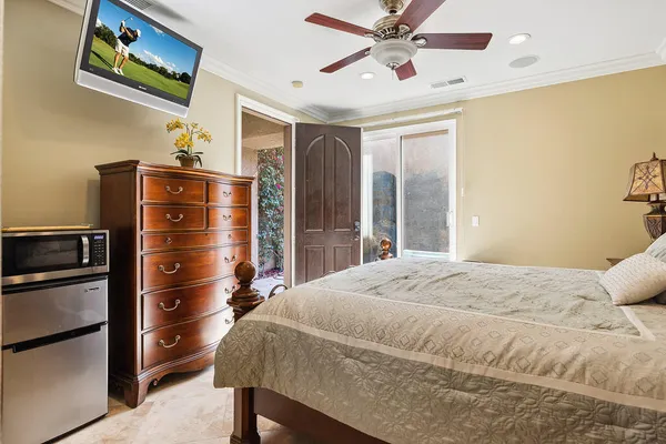 a bedroom with a bed and a refrigerator