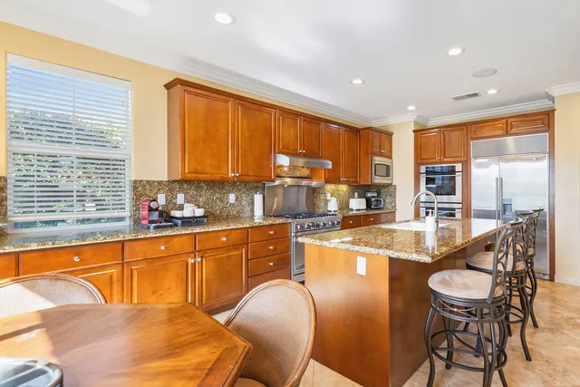 a kitchen with stainless steel appliances granite countertop a stove a sink and a refrigerator