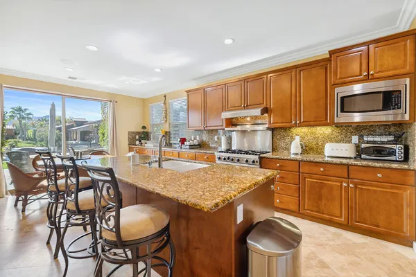 a kitchen with a stove a table and chairs