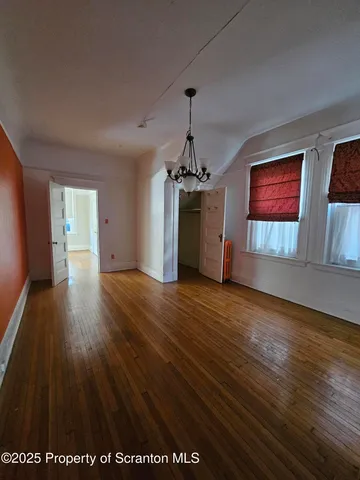 a view of a room with wooden floor