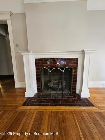 a view of a livingroom with wooden floor and fireplace