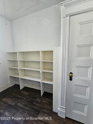 a view of walk in closet with empty racks