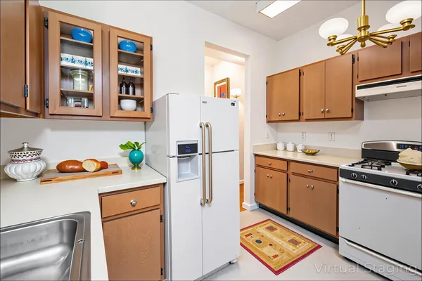 a kitchen with a refrigerator sink stove and cabinets