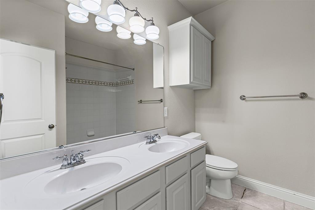 5717 Lunsford Road Plano, TX 75024 - Photo 20 of 25 a bathroom with a granite countertop sink a toilet and a mirror