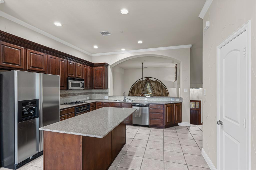 5717 Lunsford Road Plano, TX 75024 - Photo 7 of 25 a kitchen with stainless steel appliances granite countertop a sink stove and refrigerator