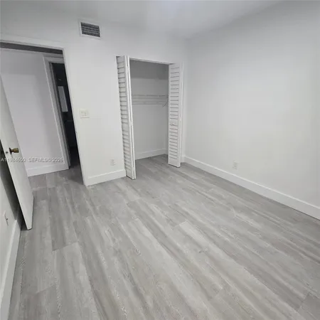 an empty room with wooden floor and stairs