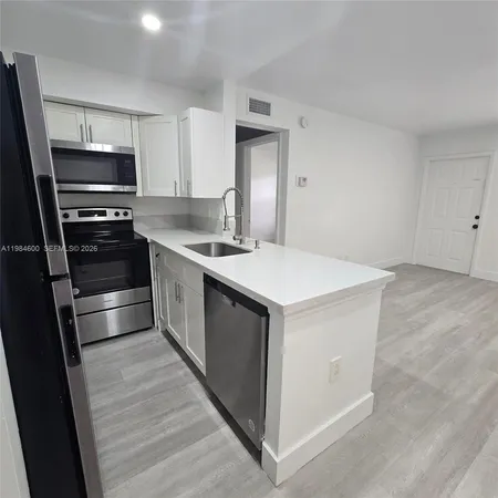 a kitchen with kitchen island a sink stove and refrigerator