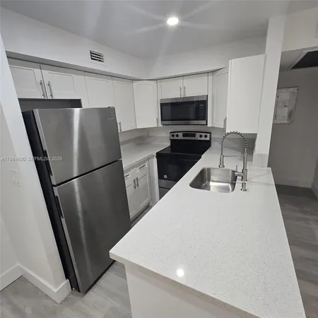 a kitchen with stainless steel appliances a refrigerator sink and microwave