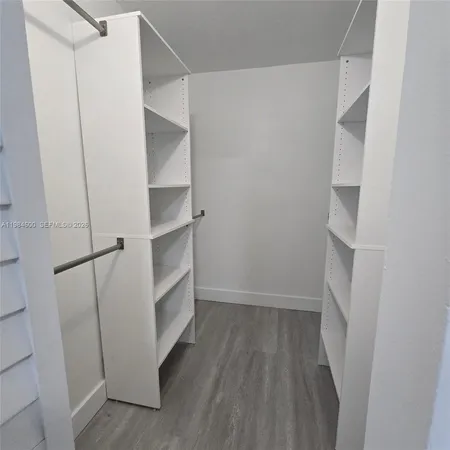 a view of walk in closet with empty racks