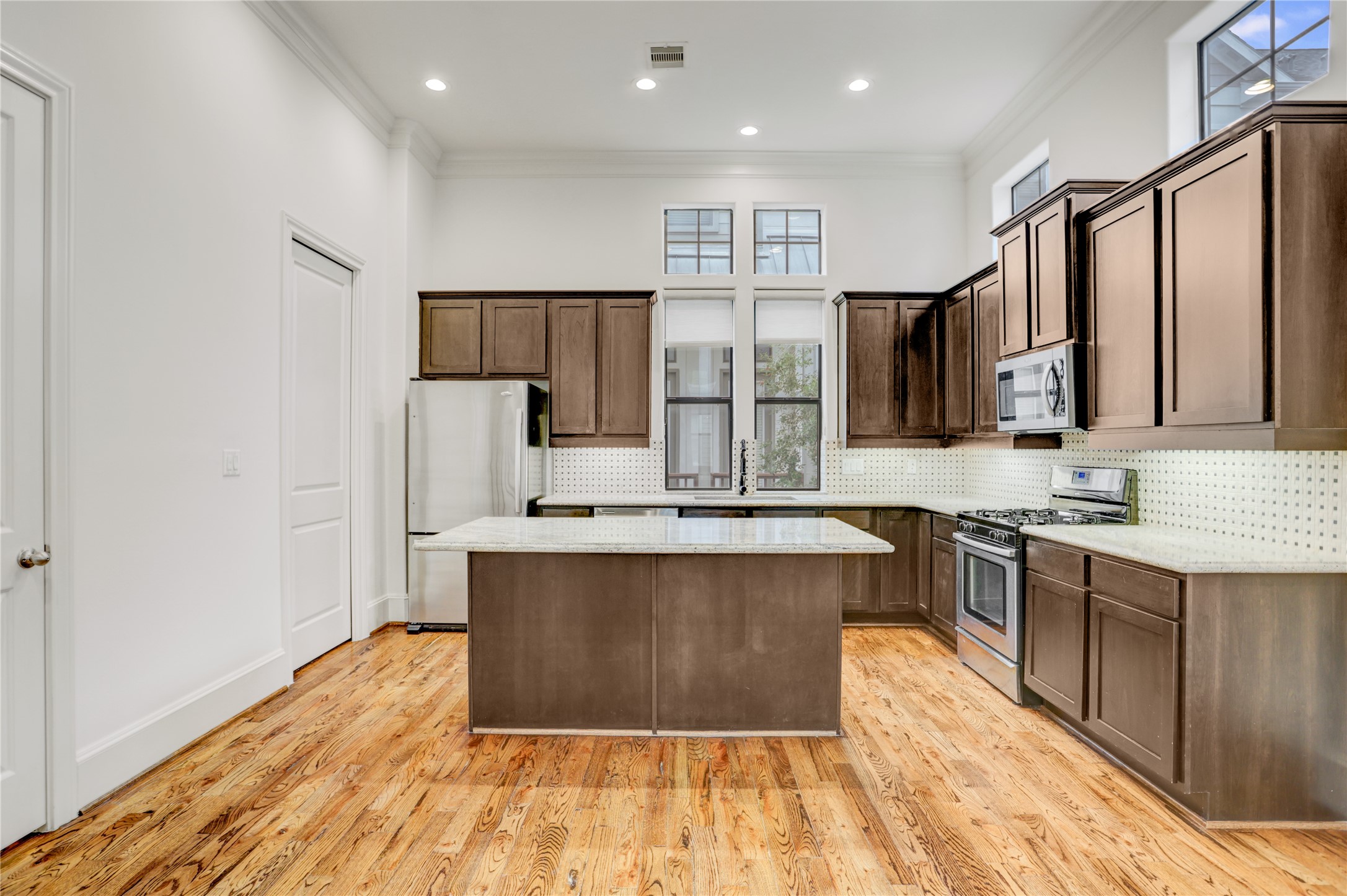 3225 Maxroy Street Houston, TX 77008 - Photo 11 of 30 The kitchen is flooded with natural light, and a convenient pantry sits just behind the pocket door to the left.