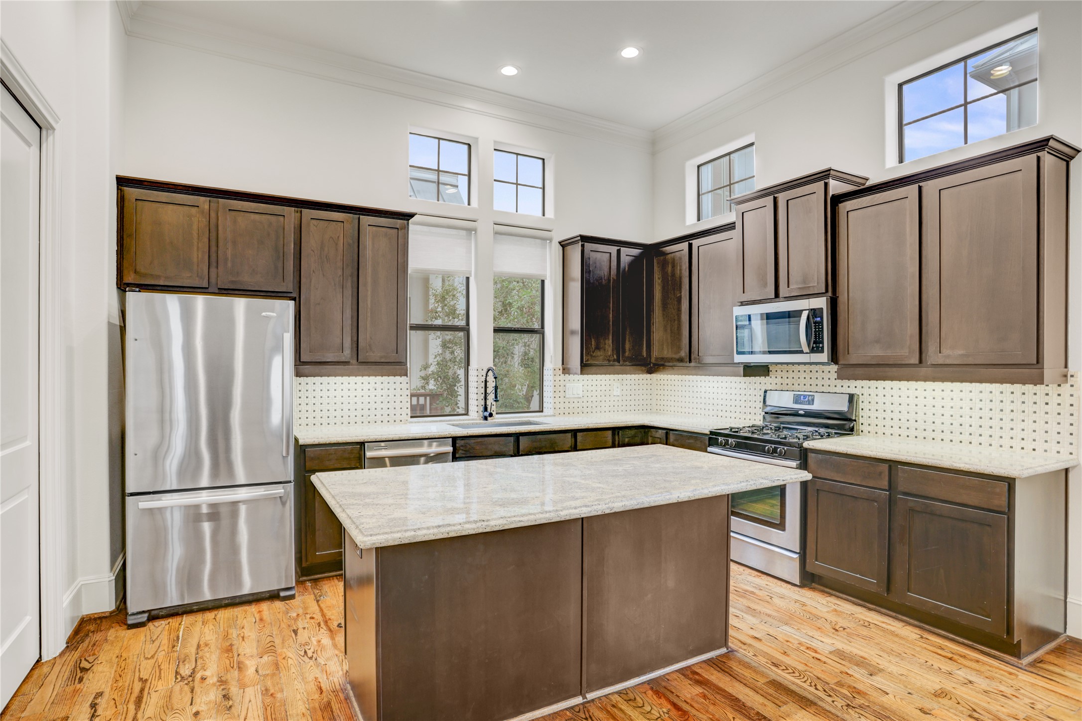 3225 Maxroy Street Houston, TX 77008 - Photo 12 of 30 The kitchen features ample storage, a striking black backsplash, and gorgeous granite countertops.