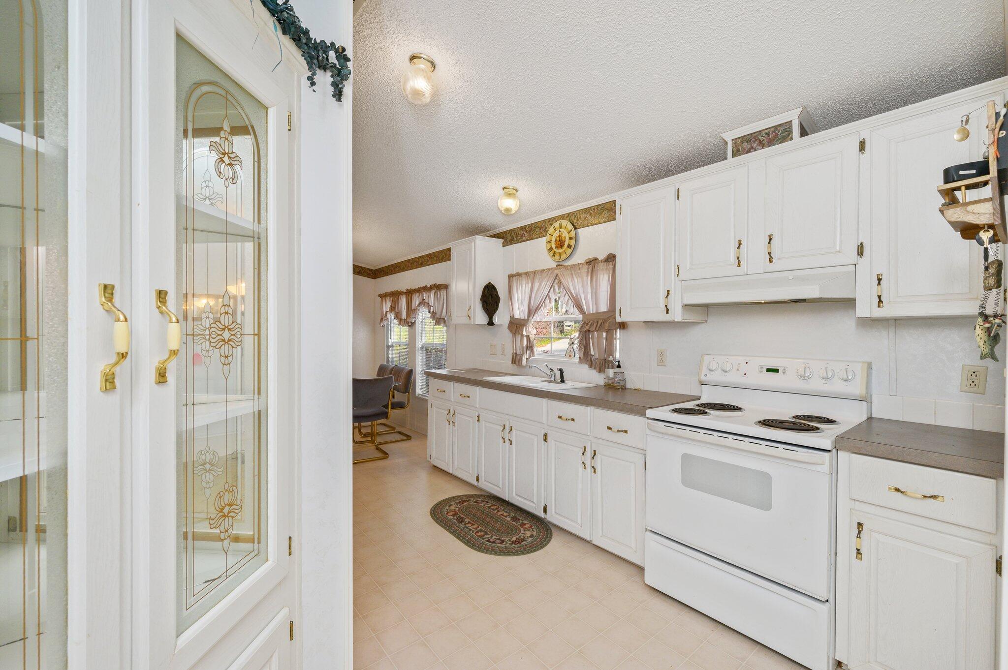 679 Squirrel Road DeFuniak Springs, FL 32433 - Photo 26 of 57 a kitchen with cabinets and white appliances