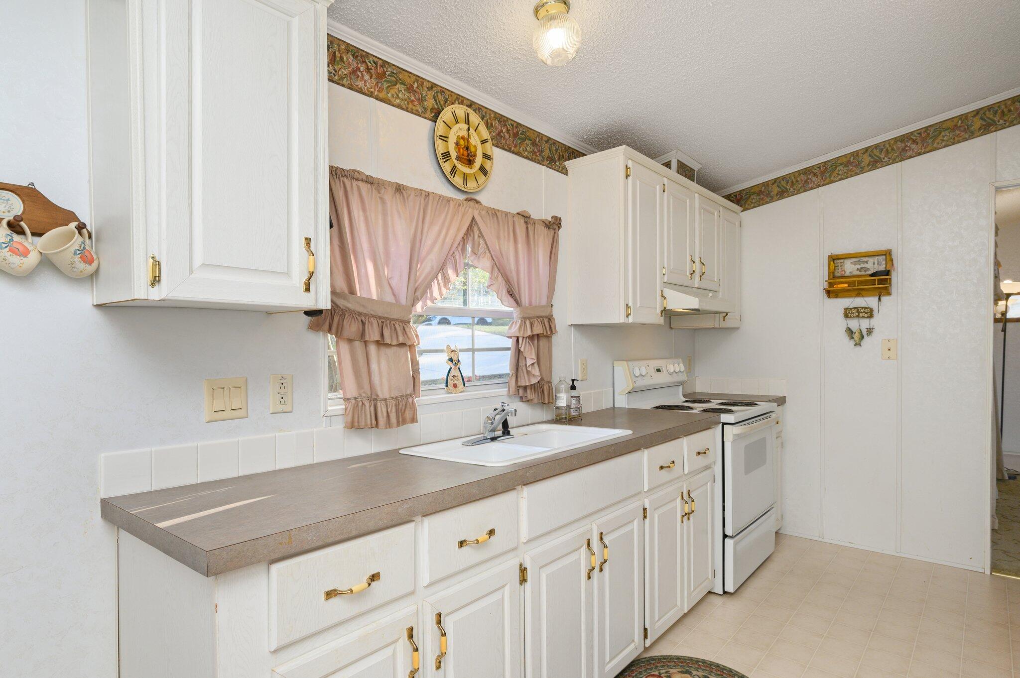 679 Squirrel Road DeFuniak Springs, FL 32433 - Photo 27 of 57 a kitchen with stainless steel appliances granite countertop a sink and a white cabinets