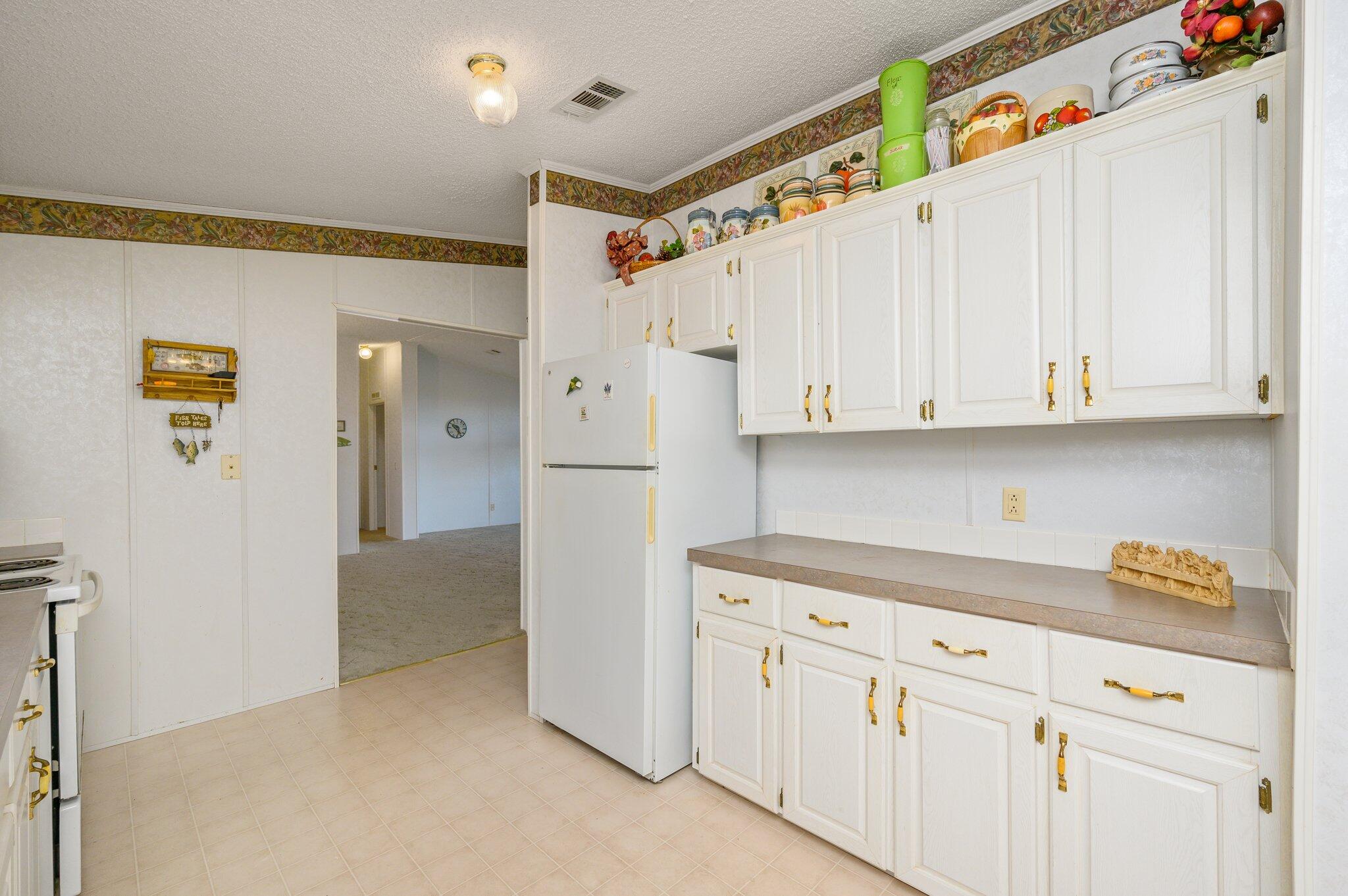 679 Squirrel Road DeFuniak Springs, FL 32433 - Photo 28 of 57 a kitchen with cabinets and a refrigerator