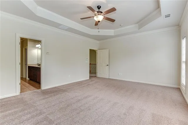 an empty room with closet and a ceiling fan