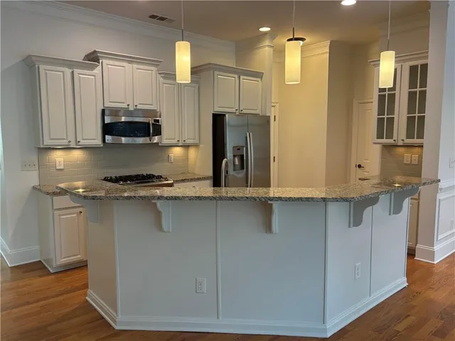 a kitchen with stainless steel appliances a refrigerator and a stove top oven