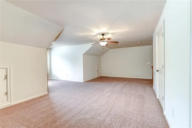 a view of an empty room with a chandelier fan