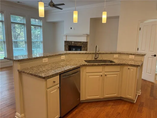 a kitchen with granite countertop cabinets stainless steel appliances and a wooden floor