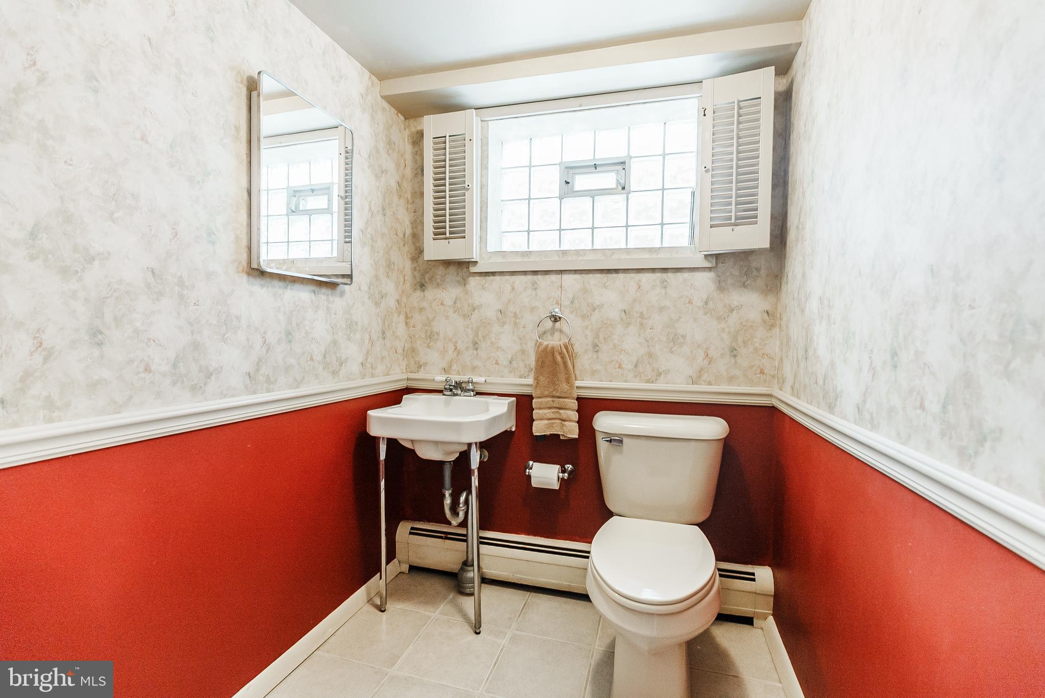 9229 Cottage Street Philadelphia, PA 19114 - Photo 12 of 14 a bathroom with a toilet a sink and mirror