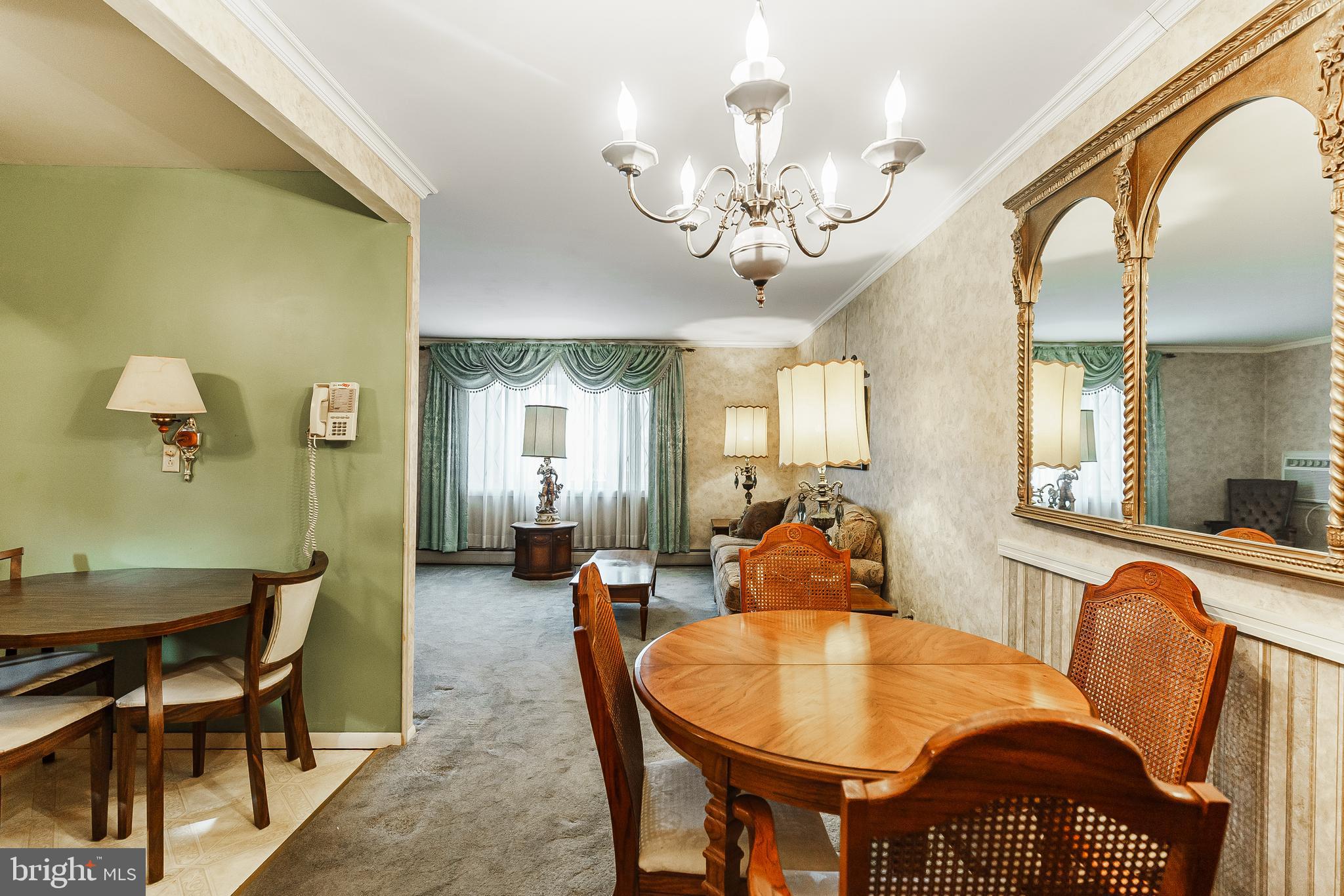 9229 Cottage Street Philadelphia, PA 19114 - Photo 4 of 14 a dining room with wooden floor a chandelier a wooden table and chairs