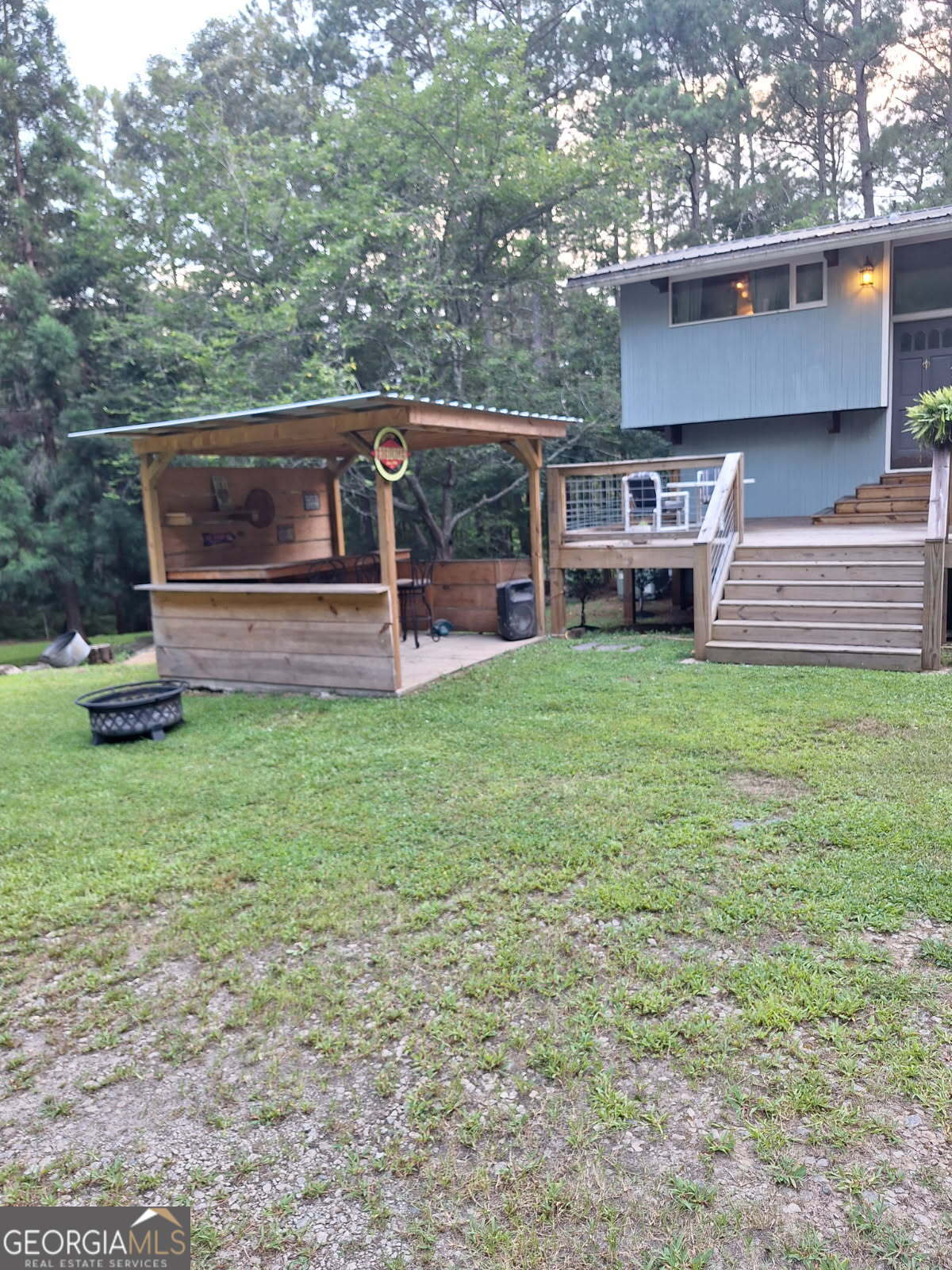1144 Turtle Cove Monticello, GA 31064 - Photo 2 of 9 a view of a backyard with table and chairs and a large tree