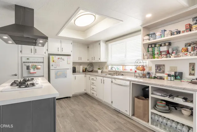 a kitchen with stainless steel appliances a sink a stove a refrigerator and cabinets