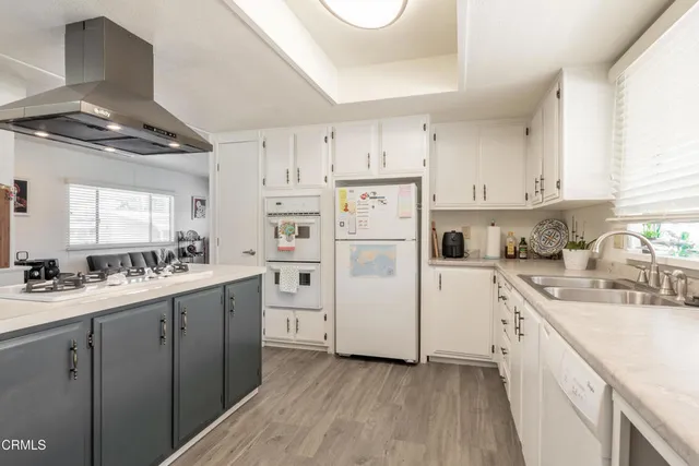 a kitchen with white cabinets and white appliances