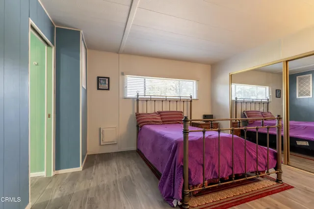 a bed sitting in a spacious bedroom next to a window