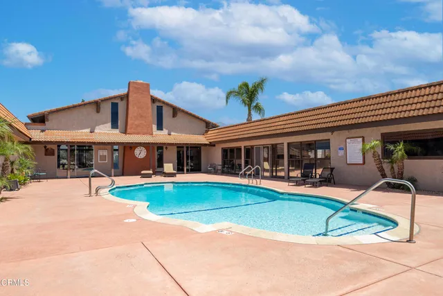 a view of a house with swimming pool and sitting area