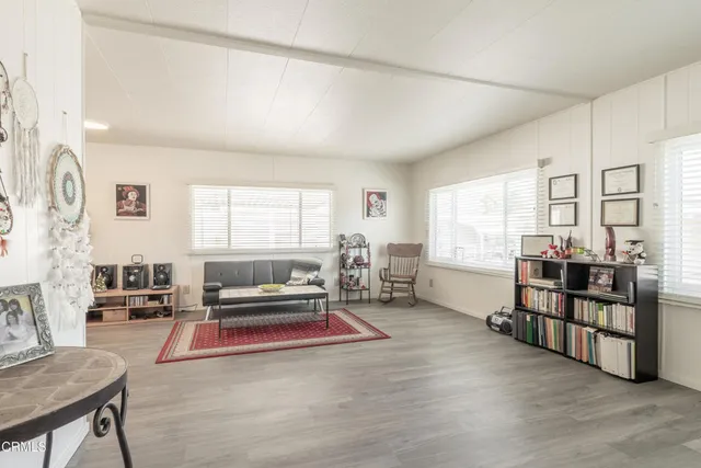 a living room with furniture a rug and a large window