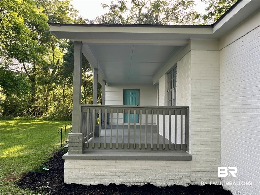8636 Boe Road Irvington, AL 36544 - Photo 6 of 22 Wooden terrace featuring a lawn