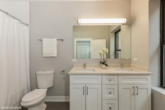 a bathroom with a toilet a sink a mirror and vanity