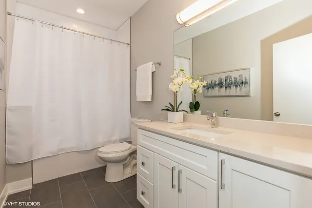 a bathroom with a sink a toilet and shower curtain