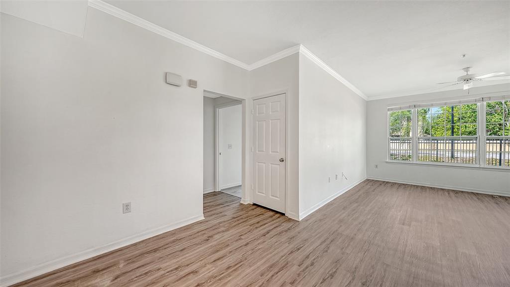 5501 Rosehill Road, Unit 105 Sarasota, FL 34233 - Photo 11 of 45 a view of an empty room with wooden floor and a window