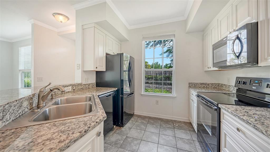 5501 Rosehill Road, Unit 105 Sarasota, FL 34233 - Photo 15 of 45 a kitchen with a stove sink and refrigerator