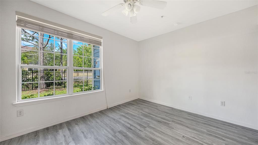 5501 Rosehill Road, Unit 105 Sarasota, FL 34233 - Photo 22 of 45 a view of empty room with wooden floor and fan