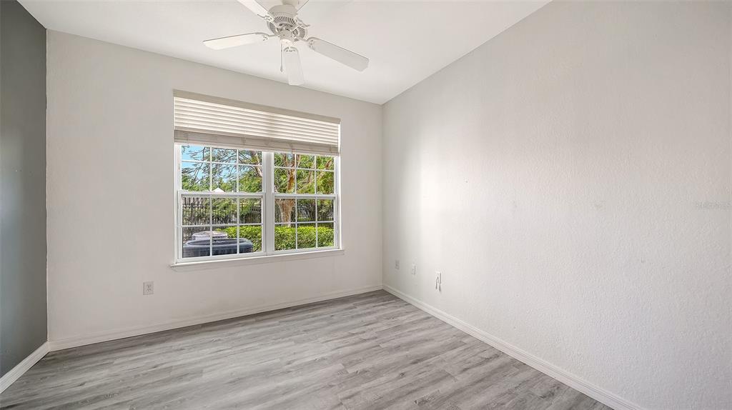 5501 Rosehill Road, Unit 105 Sarasota, FL 34233 - Photo 27 of 45 an empty room with a window and wooden floor