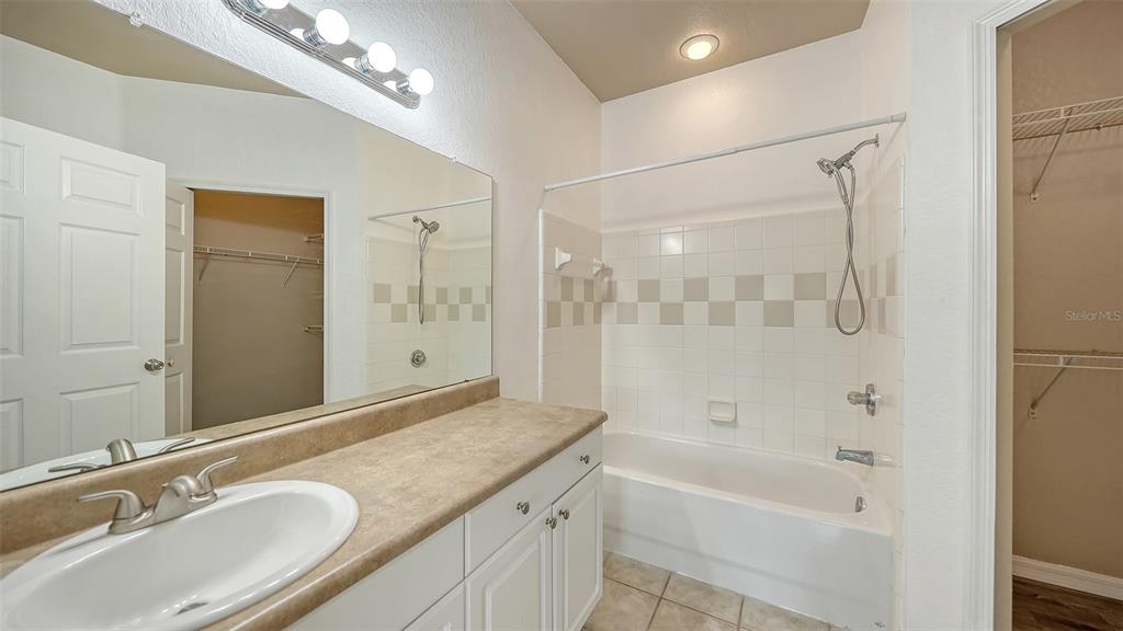 5501 Rosehill Road, Unit 105 Sarasota, FL 34233 - Photo 31 of 45 a bathroom with a granite countertop sink a mirror a bathtub and shower