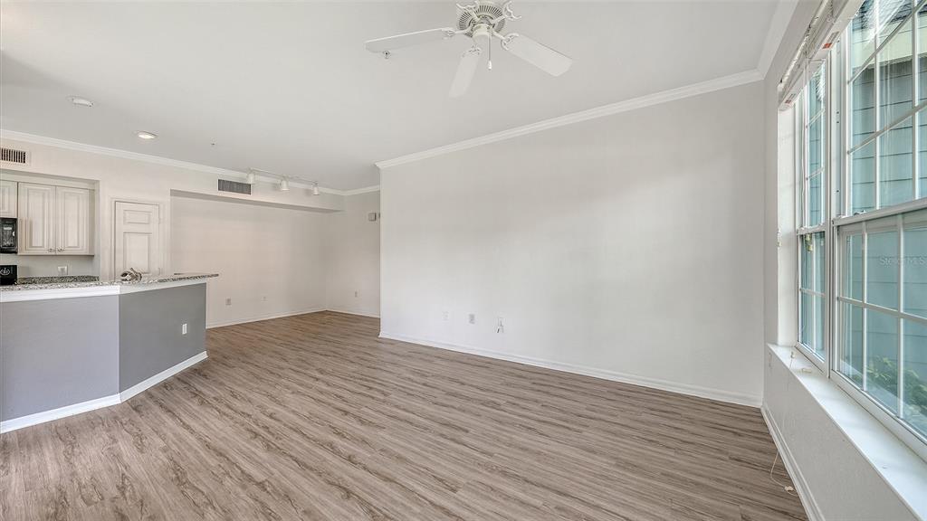 5501 Rosehill Road, Unit 105 Sarasota, FL 34233 - Photo 6 of 45 a view of an empty room with wooden floor and a window