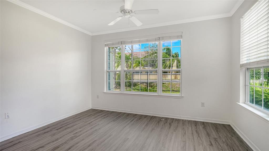 5501 Rosehill Road, Unit 105 Sarasota, FL 34233 - Photo 7 of 45 an empty room with wooden floor and windows