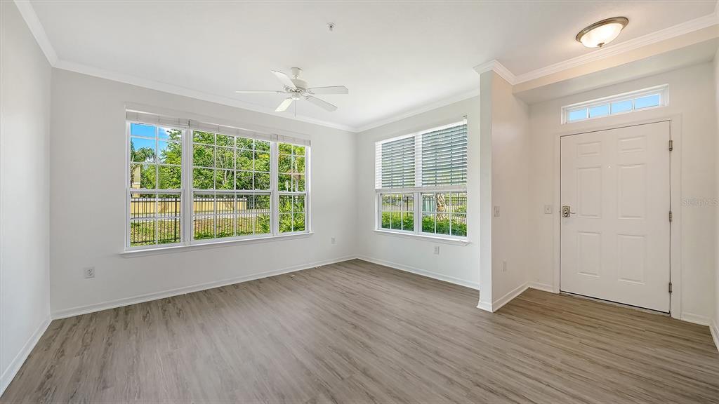 5501 Rosehill Road, Unit 105 Sarasota, FL 34233 - Photo 8 of 45 an empty room with wooden floor and windows