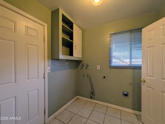 an empty room with wooden floor closet and fan